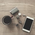 Vaping set, smartphone and coffee on the wood table.