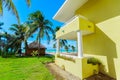 Amazing fragment of view of bright yellow building standing near the beach and tranquil turquoise ocean on sunny summer gorgeous,