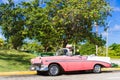 American rose white convertible vintage car parked in the sidestreet in