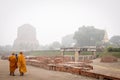 VARANASI, INDIA - DECEMBER 2, 2016: Buddhist monks and tourists come to visit and pray in the misty morning at Dhamekh Stupa. Royalty Free Stock Photo