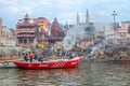 old wooden boats at the pier on the border of river Ganges in morning light with people on pier in Varanasi Royalty Free Stock Photo