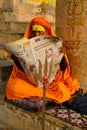 Indian man reading news in morning newspaper on the varanasi ghat of historical city on February 3, 2021