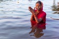 Varanasi, India, 27 Mar 2019 - Hindu woman in sari making offering to the gods in Ganga river at Varanasi, India