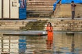 Indian elderly woman bathing in water holy Ganga river in morning. Varanasi. India