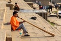 Man playing Didgeridoo on ganga river bank in morning. Varanasi. India