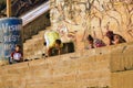 Varanasi, India: Bunch of foreigner men in hipster style doing yoga in the Morning with a trainer against wall