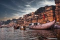 Varanasi, India: Dramatic sunset in a holy hindu place of worship with lots of tourists on boats and ancient