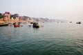 Varanasi, India: Tourist and pilgrim sightseeing on wooden boats in Ganges river against Ghat and Banaras Royalty Free Stock Photo