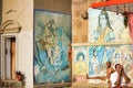 Varanasi, India: Wide angle shot of People doing yoga during morning against colorful Hindu god such as shiva