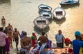 Pilgrims and tourists at Varanasi Ganges riverbank with view of wooden boats Royalty Free Stock Photo