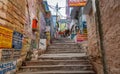 Varanasi narrow alleyway with old weathered buildings and long stairways Royalty Free Stock Photo