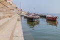 VARANASI, INDIA - OCTOBER 25, 2016: Small boats at Ghats riverfront steps leading to the banks of the River Ganges in Royalty Free Stock Photo