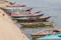 VARANASI, INDIA - OCTOBER 25, 2016: Small boats near Ghats riverfront steps leading to the banks of the River Ganges in Royalty Free Stock Photo
