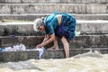 Varanasi, India, september 19, 2010: Old indian woman making laundry in ganges river in Varanasi.