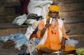 Varanasi, India: Wide angle shot of an hindu bearded sadhu, pilgrim portrait with steel glass drinking water