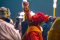 17.12.2019, Varanasi, India. Yogi in colorful clothes with flowers on his head among the crowd of people. Side view