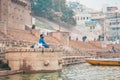 18.12.2019, Varanasi, India. A yogi sits on a pier by the river and meditates. Side view. Outdoor