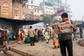 VARANASI, INDIA: Young man reads a newspaper in the crowd of hindu people at the morning