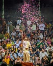 Priest throwing flower petals during Ganga aarti on banks of holy river Ganges in one of the oldest living cities of World and Royalty Free Stock Photo