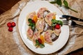 Vareniki with strawberries, mint on a large white plate, on the background of kraft paper