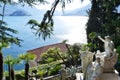 View to ancient sculptures of the Villa Monastero garden in Varenna, to the lake Como and Bellagio peninsula.