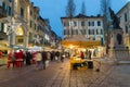 Christmas market at dusk, street with crowd of people and christmas lights