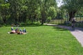 Some people sunbathe, stretched out on a lawn in the park. Royalty Free Stock Photo