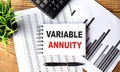 VARIABLE ANNUITY text on notebook on chart with calculator and pen