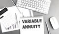 VARIABLE ANNUITY text on a notebook with clipboard on grey background