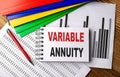 VARIABLE ANNUITY text on a notebook with pen, folder on a chart background