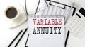VARIABLE ANNUITY text on the paper with calculator, notepad, coffee ,pen with graph