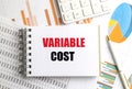 Variable cost phrase on notepad surrounded by financial documents, pen and calculator Royalty Free Stock Photo