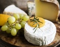 Variation of cheese and green grapes on a wooden platter food photography recipe idea Royalty Free Stock Photo