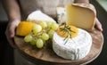 Variation of cheese and green grapes on a wooden platter food photography recipe idea Royalty Free Stock Photo