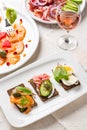 Variation of healthy open sandwiches on Pumpernickel bread with vegetables, salmon, Prosciutto and appetizers