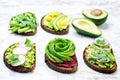 Variation of healthy rye breakfast sandwiches with avocado and toppings