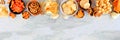 Variation of salty snacks, above view top border on a grey stone banner background