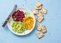 Variations of hummus and crackers. Pumpkin, turmeric, avocado, beetroot hummus with olive oil, sesame seeds and micro greens on a Royalty Free Stock Photo