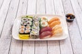 Varied sushi menu with pieces of red shrimp nigiri, Norwegian salmon and red tuna, uramaki stuffed with surimi, avocado, nori