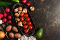 Varied vegetables and mushrooms on a rustic ceramic dish. The concept of healthy eating. Dark brown background, top view, copy spa Royalty Free Stock Photo