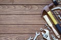 Varieties handy tools on wooden background. Hammer, saw, wrenches, adjustable wrench, paint brushes, nail, nuts and bolts on wood