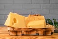 A variety of aged cheeses in a substrate on a wooden table against a brick wall Royalty Free Stock Photo