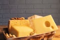 A variety of aged cheeses in a substrate on a wooden table against a brick wall Royalty Free Stock Photo