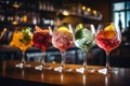 Variety of alcoholic cocktails on the bar counter in night club, Five colorful gin tonic cocktails in wine glasses on the bar
