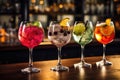 Variety of alcoholic cocktails on the bar counter in a nightclub, Five colorful gin tonic cocktails in wine glasses on the bar
