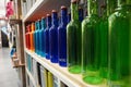 Variety of assorted colored bottles stacked in a row on shelf for sale. Decoration concept. Antique bottle are for sale in super