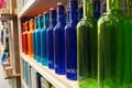 Variety of assorted colored bottles stacked in a row on shelf for sale. Decoration concept. Antique bottle are for sale in super