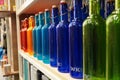 Variety of assorted colored bottles stacked in a row on shelf for sale. Decoration concept. Antique bottle are for sale in super Royalty Free Stock Photo