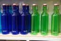 Variety of assorted colored bottles stacked in a row on shelf for sale. Decoration concept. Antique bottle are for sale in super Royalty Free Stock Photo