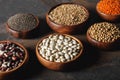 Variety of beans, chia seeds and oat groats in wooden bowls